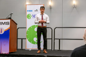 Man standing beside podium in shirt and tie